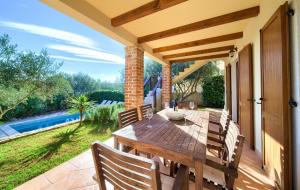 a wooden table and chairs on a patio at Villa Rustika in Dobrinj