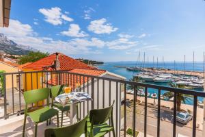 a balcony with a table and chairs and a view of a harbor at Lux Apartments Marko in Baška Voda