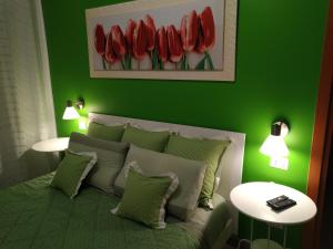 バーリにあるAlloggio breve Antheaの緑のベッドルーム(赤いチューリップのベッド付)