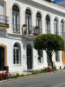 Biały budynek z drzewem przed nim w obiekcie Casa Ribera Centro w mieście Ayamonte