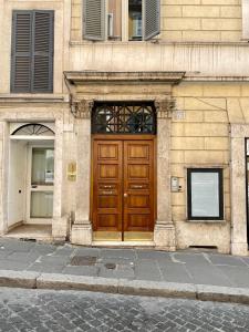 uma porta de madeira na lateral de um edifício em Barberini Apt close to Fontana di Trevi em Roma