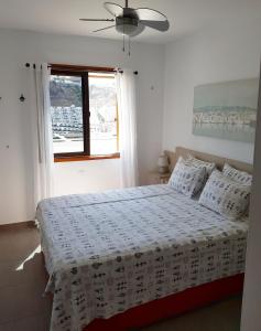 a white bedroom with a bed with a window at Tranquility Arimar Apartment Puerto Rico in Puerto Rico de Gran Canaria