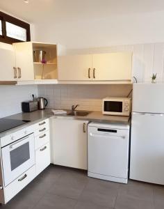 a kitchen with white appliances and white cabinets at Tranquility Arimar Apartment Puerto Rico in Puerto Rico de Gran Canaria