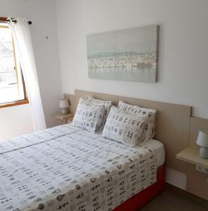 a bedroom with a bed with white sheets and pillows at Tranquility Arimar Apartment Puerto Rico in Puerto Rico de Gran Canaria
