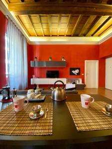 uma cozinha com paredes vermelhas e uma mesa com panelas de chá em Barberini Apt close to Fontana di Trevi em Roma