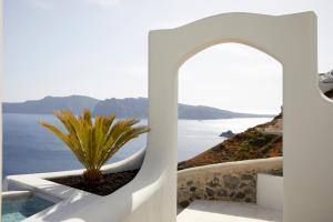 a view of the ocean from a white building at Hom Santorini in Oia