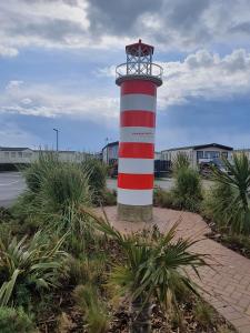 a lighthouse with a red and white stripes at Sea let’s selsey in Selsey