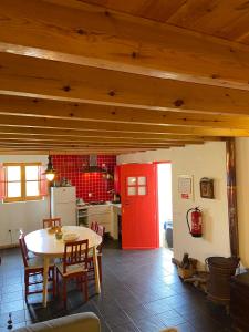 a kitchen with a table and a red door at Casa Pedralva in Vila do Bispo