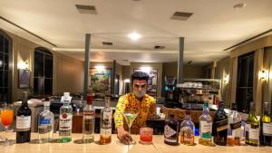 a man standing behind a bar with bottles of alcohol at WelcomHeritage Cheetahgarh Resort & Spa in Bera