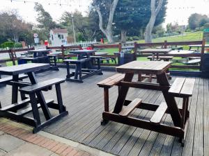 a group of picnic tables and benches on a deck at Sea let’s selsey in Selsey