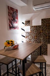 uma sala de jantar com uma mesa de madeira e cadeiras em SAN GIACOMO APARTMENT em Caltagirone