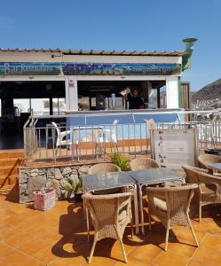 a table and chairs on a deck of a boat at Tranquility Arimar Apartment Puerto Rico in Puerto Rico de Gran Canaria