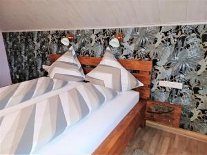 two beds in a bedroom with a tropical wallpaper at Ferienwohnungen Finke in Frankenau