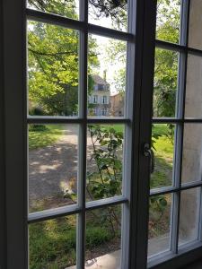 an open window looking out at a house at L'Orangerie, Château St Justin in Saint-Justin