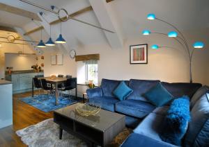a living room with a blue couch and a table at Stone Barn in Minehead