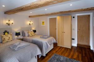 a bedroom with two beds and a closet at Stone Barn in Minehead