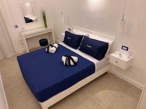 - une chambre avec un lit doté de draps bleus et d'oreillers bleus dans l'établissement St. Vincent Apartment, à Castellammare di Stabia