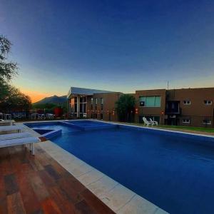 una gran piscina azul frente a un edificio en Complejo Los Paraísos en Potrero de los Funes