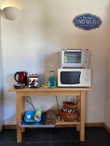 a microwave oven sitting on top of a wooden table at Casa Pedralva in Vila do Bispo