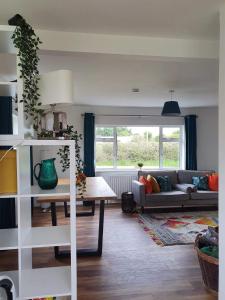 sala de estar con sofá y mesa en Bungalow fully renovated 2022 close to slob lands and beach, en Ballygarrett