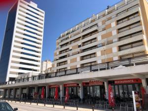 a building with tables and chairs in front of it at Two bedroom apartment near beach and Casino in Figueira da Foz