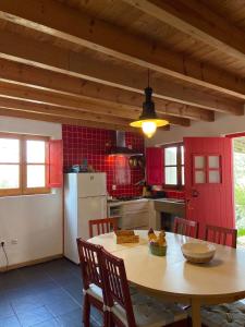 eine Küche mit einem Tisch und einer roten Tür in der Unterkunft Casa Pedralva in Vila do Bispo