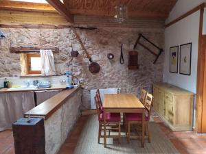 a kitchen with a wooden table and chairs in a room at Las Casitas del Salado - La Casita roja in Santamera