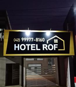 una señal de rotura de hotel frente a un garaje en Hotel ROF, en Telêmaco Borba