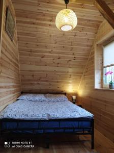 1 dormitorio con 1 cama en una habitación de madera en Gajówka Żłobek, en Żłobek
