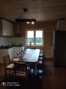 a kitchen with a table and chairs in a room at Gajówka Żłobek in Żłobek