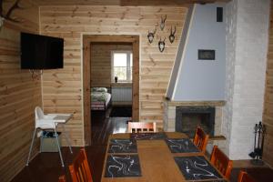 a dining room with a table and a fireplace at Gajówka Żłobek in Żłobek