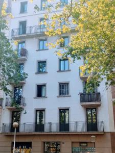 a tall white building with windows and balconies at Diagonal Apartments in Barcelona