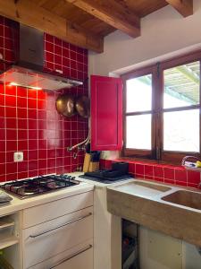 a kitchen with red tile on the wall and a stove at Casa Pedralva in Vila do Bispo