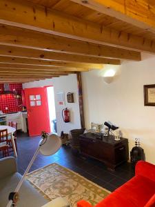 ヴィラ・ド・ビスポにあるCasa Pedralvaのリビングルーム(赤いドア、赤いソファ付)