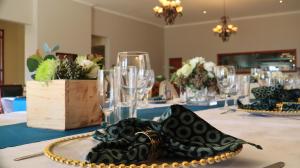 a table with a black and gold plate on it at Hibon Lodge in Hekpoort