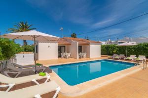 a villa with a swimming pool and patio furniture at Villa Marina -Cala EnPorter- in Cala en Porter