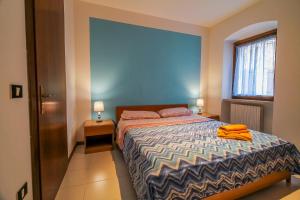 a bedroom with a bed with a blue wall at Cà Irene - Cà Battistoni in Brenzone sul Garda