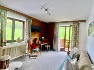 a living room with a couch and a table and windows at Ferienwohnung 2 in Taxenbach