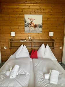 two white beds in a room with a wooden wall at Ferienwohnung 2 in Taxenbach