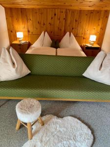 - une chambre avec un grand lit et un tabouret dans l'établissement Ferienwohnung 4, à Taxenbach