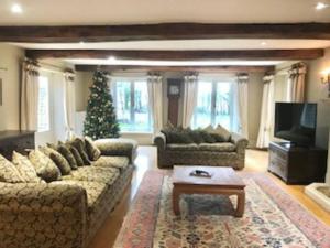 a living room with two couches and a christmas tree at Stunning Country Farm House between Bristol & Bath in Bristol