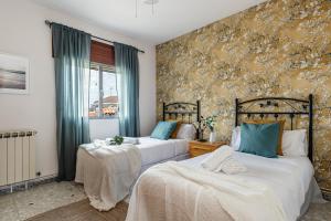 2 camas en un dormitorio con cortinas azules en BNBHolder La Casa de los Abuelos TITULCIA en Titulcia