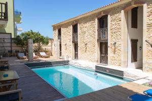 a swimming pool in front of a building at Volakas Beachfront Suites in Rethymno