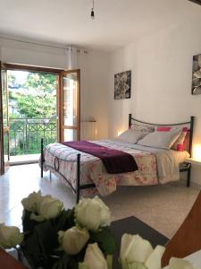 a bedroom with a bed and a window and flowers at Appartamento “BellaVista” a Norma in Norma