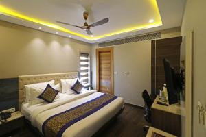 1 dormitorio con 1 cama y ventilador de techo en Hotel The IVY Grand With Free Secured Parking, en Nueva Delhi