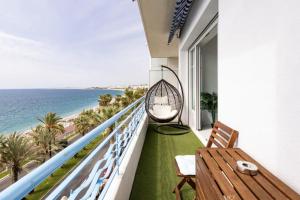 uma varanda com um baloiço de vime e o oceano em Sea view - Promenade des Anglais em Nice