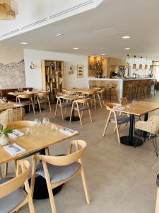 a dining room with wooden tables and chairs at Hôtel L'Albatros in Saint-Trojan-les-Bains