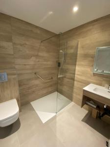 a bathroom with a shower and a toilet and a sink at Hôtel L'Albatros in Saint-Trojan-les-Bains