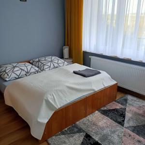 a bed with a white comforter and pillows in a room at Willa Różana in Wola Kalinowska