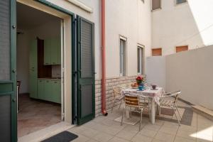 una puerta abierta a un patio con mesa y sillas en Casa Vacanze Kalocéri, en Torre dell'Orso